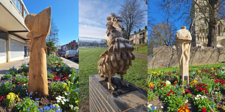 Three wooden sculptures in outdoor settings. Left: Abstract figure among flowers. Centre: Stylized bird on a brick pedestal. Right: Intricate design near a historic building, surrounded by colourful flowers.