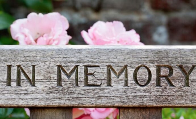 in memory on a bench with flowers at the back