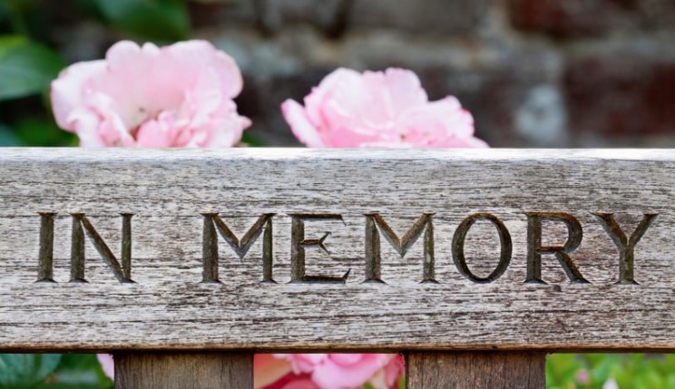 in memory on a bench with flowers at the back