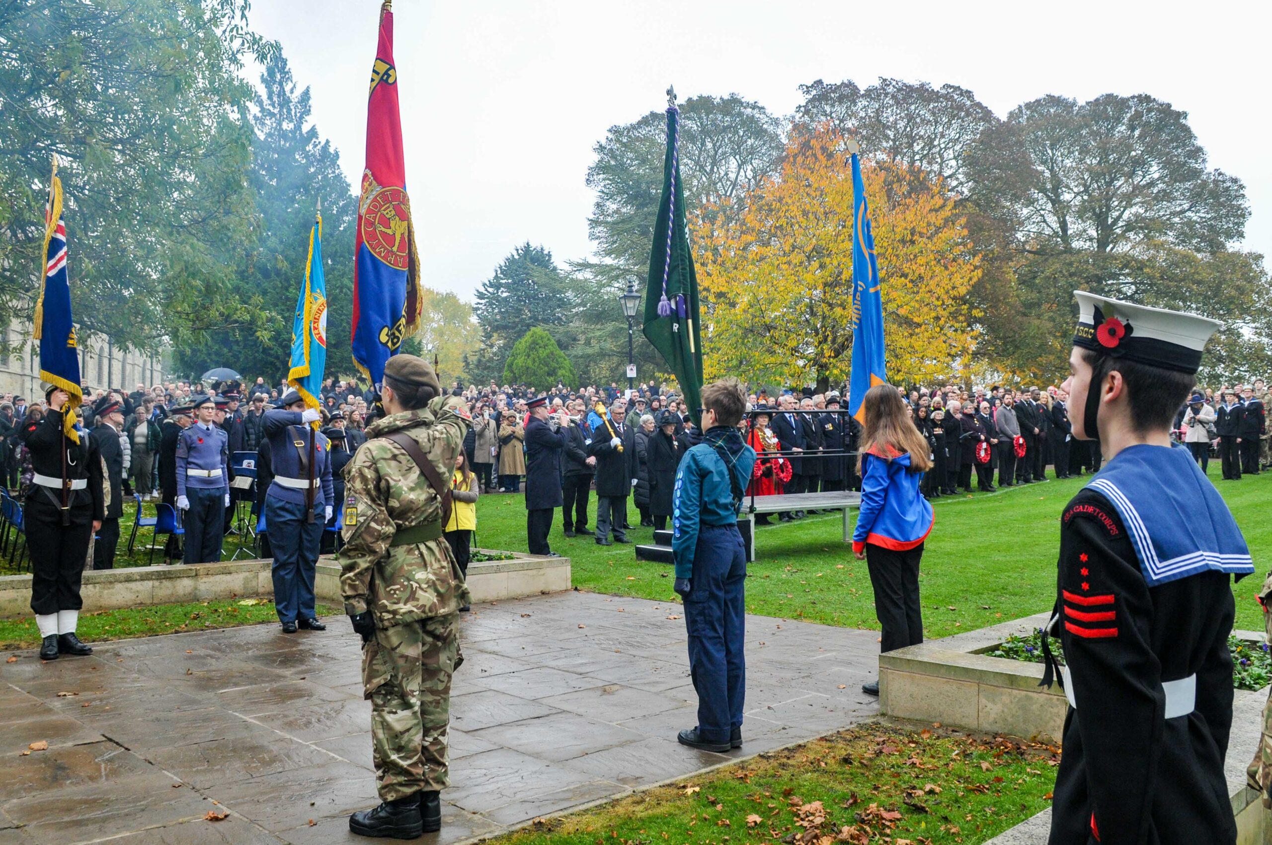 wreath laying service in priory gardens with crowds of people