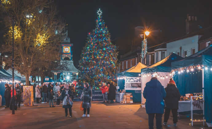 stalls and people in the square with a chritmas tree in the background