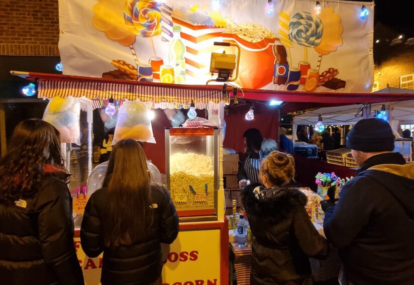 A Popcorn stand with people ordering popcorn