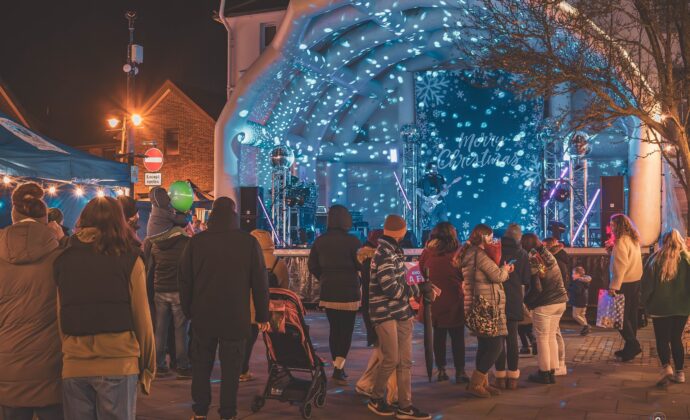 Stage at Twilight markets with people watching
