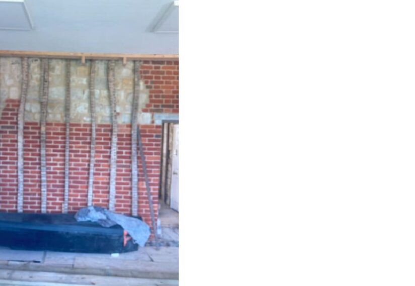 Priory House internal east wall repaired in brick with evidence of original stone and timber remaining.
