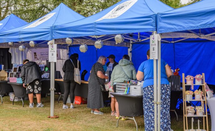 stalls holders under blue gazebo with customers
