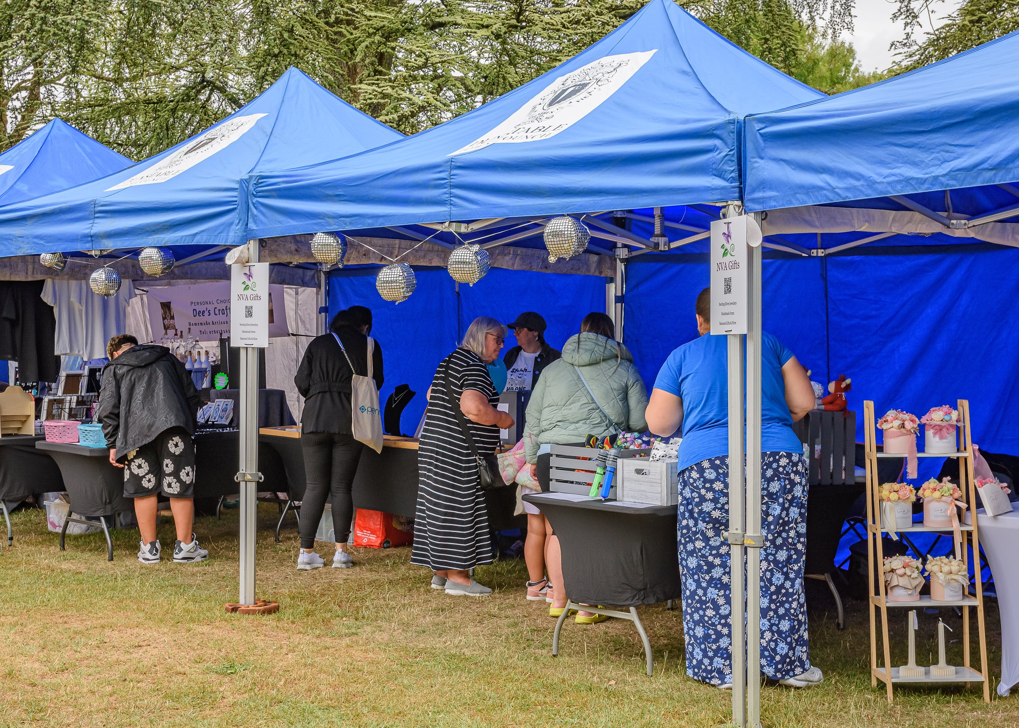 stalls holders under blue gazebo with customers