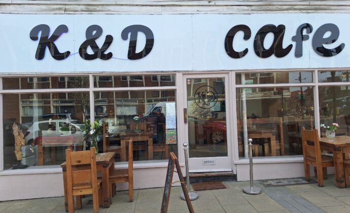 K & D cafe front with chairs outside on the street