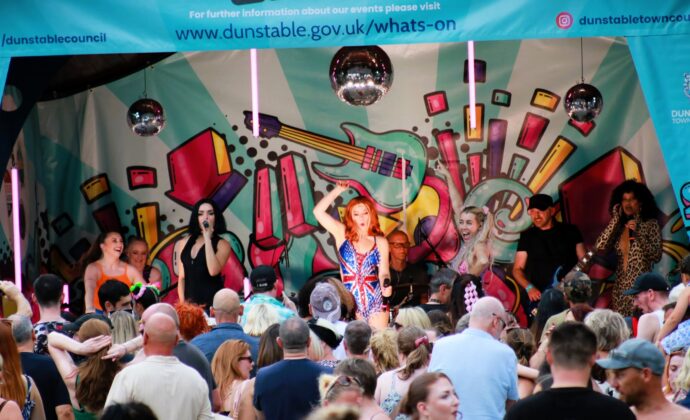 crowds of people with the tribute act the spice girls performing in the background