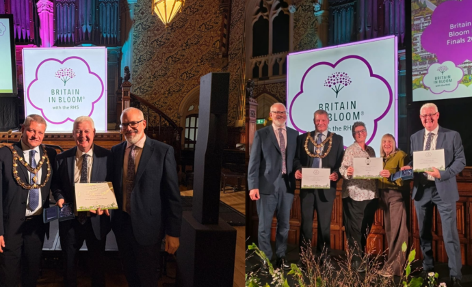 wo individuals proudly holding their awards at a formal ceremony, smiling and celebrating their achievements.